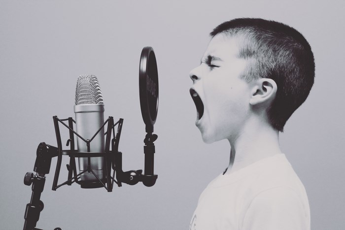 Boy screaming into a Rode microphone in a studio