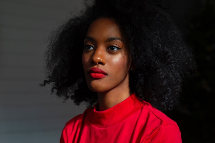 African American woman with black hair wearing a red shirt
