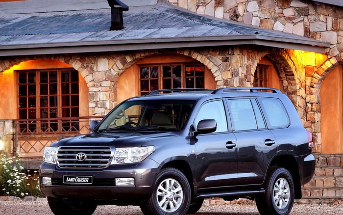 Dark gray Toyota Land Cruiser parked in front of a stone building