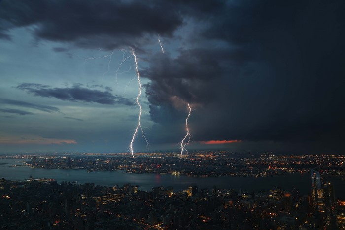 Lightning strikes over a city at night during a thunderstorm