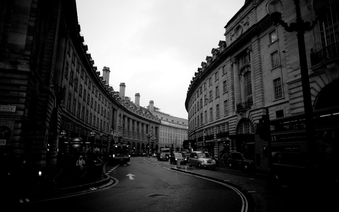 Black and white street scene in London with buildings and cars