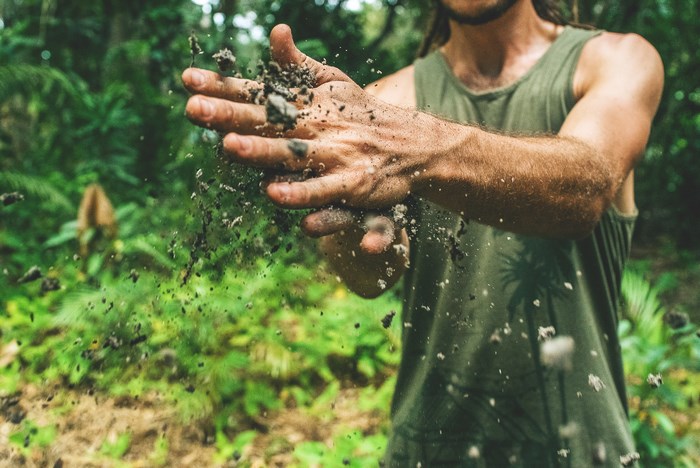 Man throwing dirt in a forest