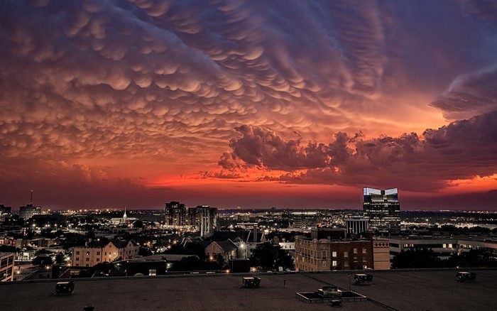 Mammatus clouds over a city at sunset