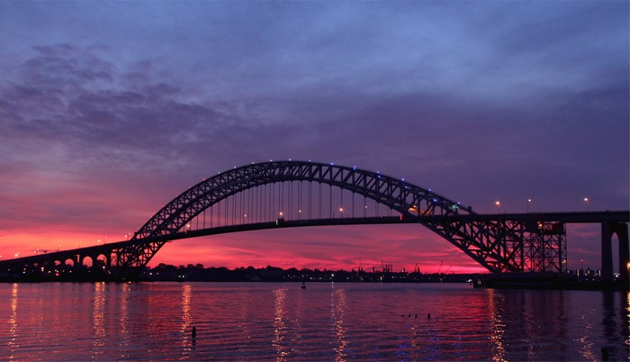 Bridge over water at sunset with colorful sky
