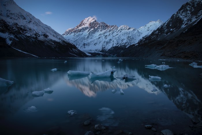 Aoraki/Mount Cook reflected in a calm lake with icebergs