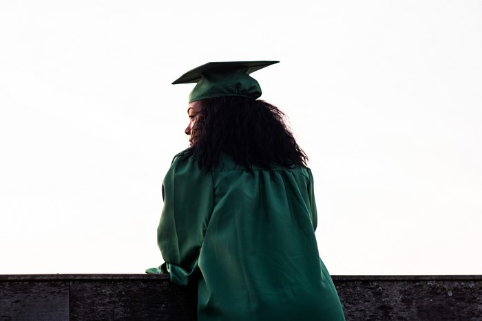 Young woman in graduation gown and cap