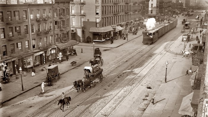 Vintage street scene with horse-drawn carts and trolley
