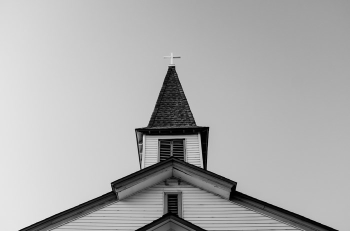 Church steeple with a cross against a clear sky
