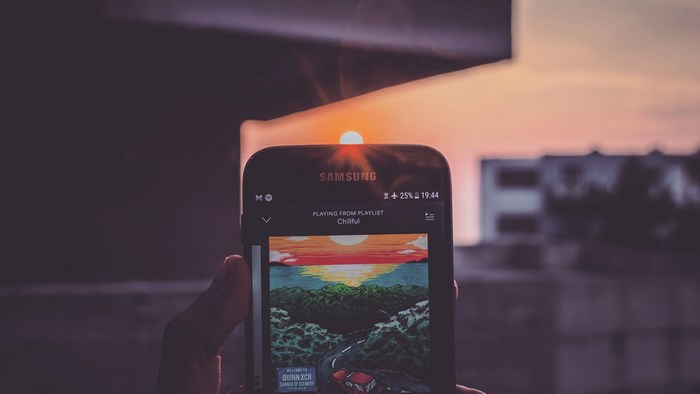Samsung smartphone playing music at sunset