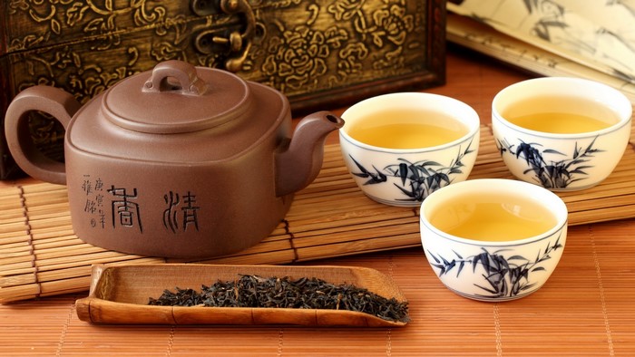 Tea ceremony with teapot, cups, and tea leaves