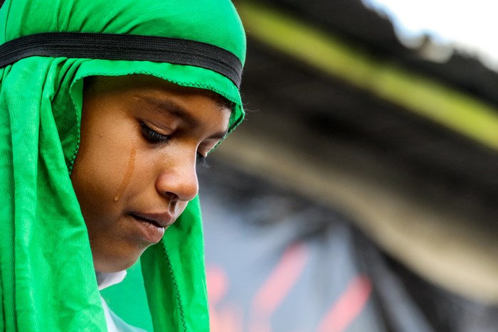Man in green swimming cap with tear on face