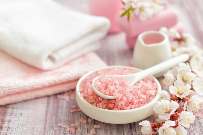 Pink bath salts with flowers and towels