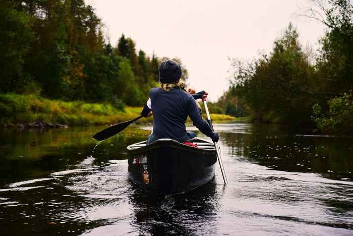 Two people canoeing on a river in Sweden