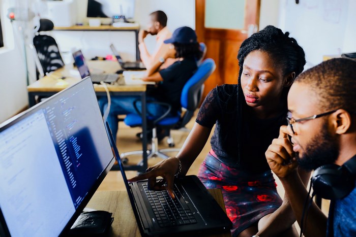 Two people collaborating on a computer in an office