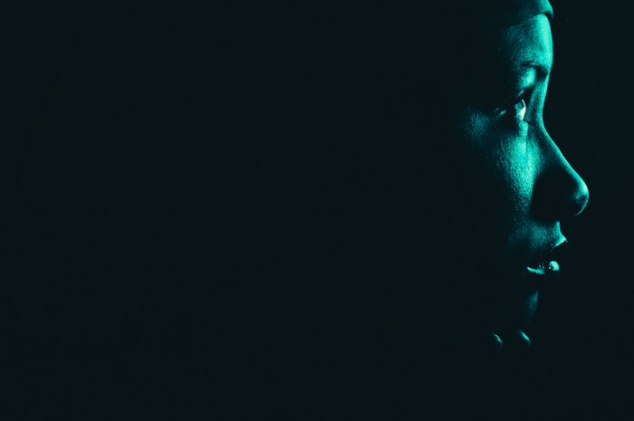 Close-up profile of a woman's face illuminated by green light