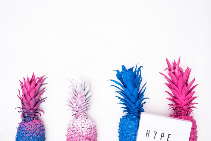 Four painted pineapples with a lightbox that says HYPE