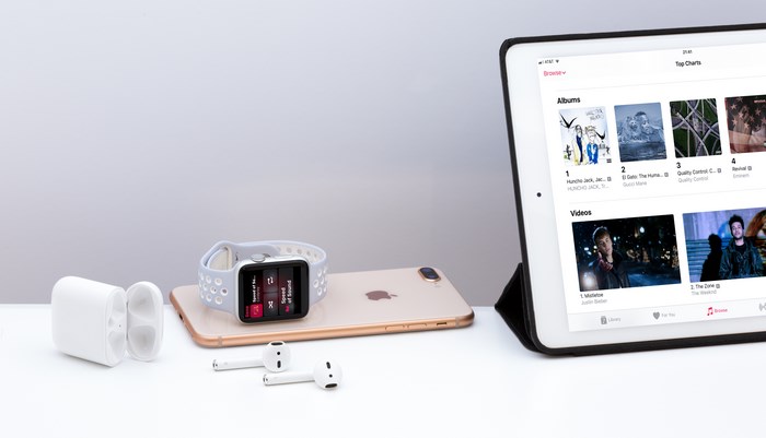 Apple Devices on White Desk with Music Playing