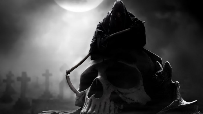 Grim Reaper sitting on a skull in a graveyard