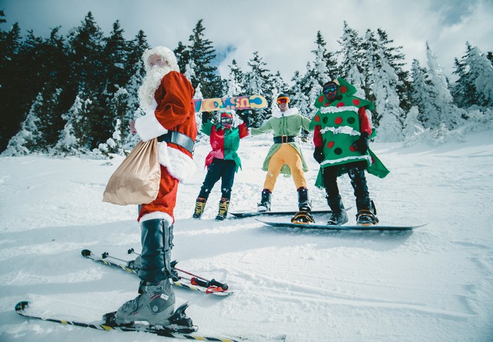 Santa, Elves, and a Christmas Tree on a Snowy Slope