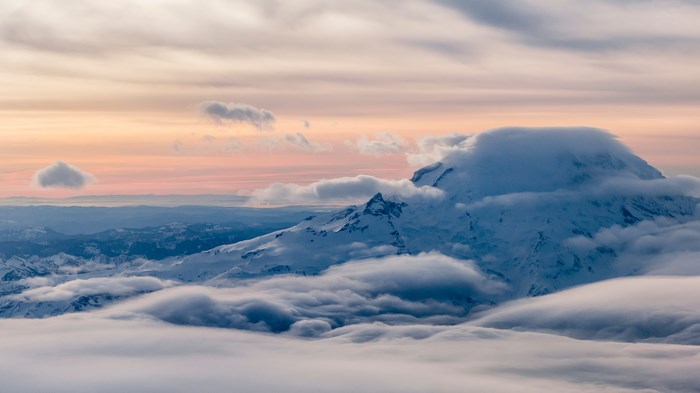 Mount Rainier covered in clouds at sunset