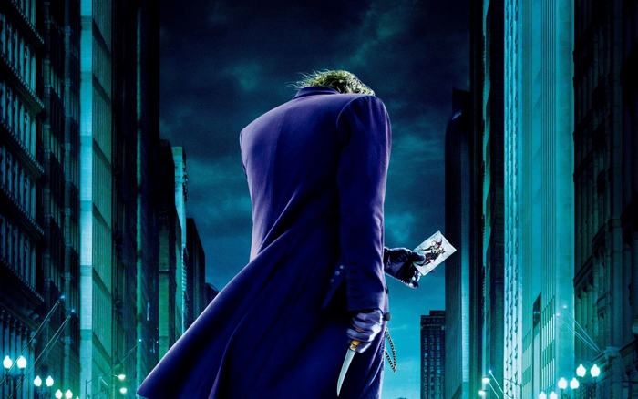 Joker from The Dark Knight holding a playing card and knife