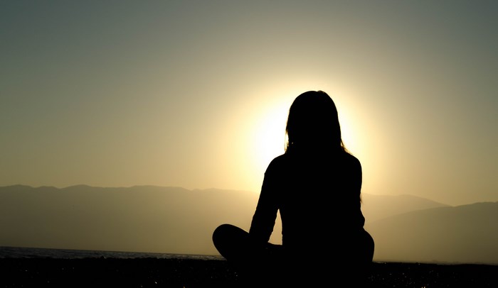 Silhouette of Woman Meditating at Sunset