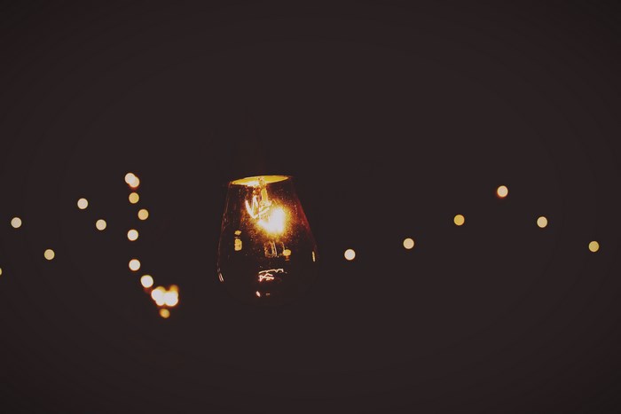 A single light bulb with bokeh lights in the background