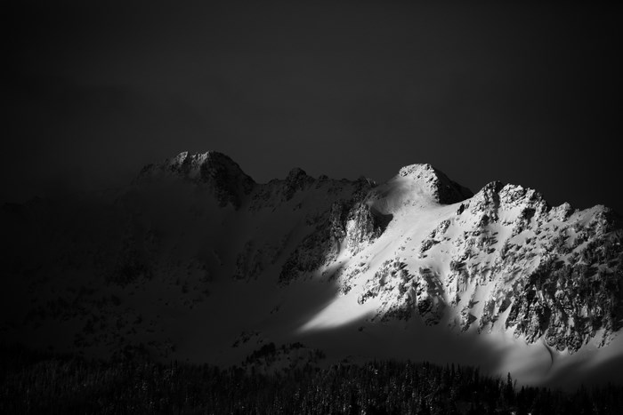 Snow-covered mountain range under a dark sky