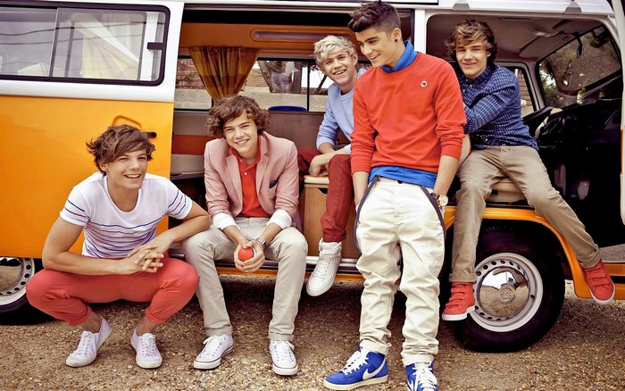 One Direction boys posing by a van