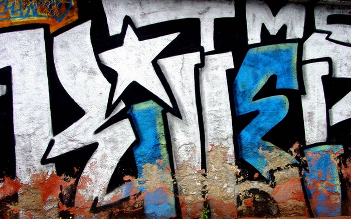 Graffiti art with white and blue letters on a wall