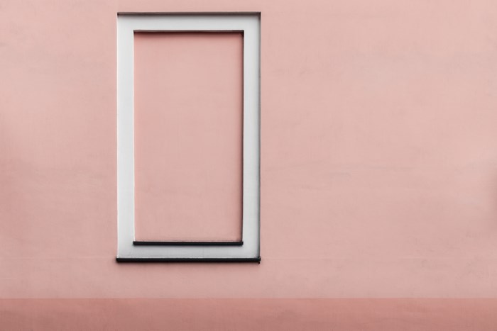 Minimalist pink building facade with a rectangular frame