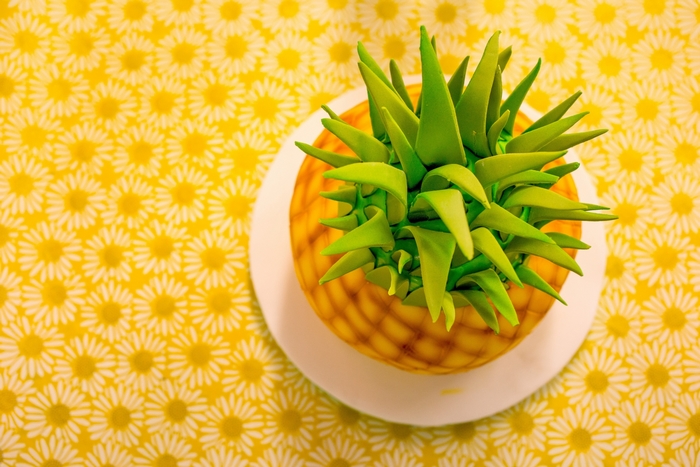 Pineapple cake on a yellow floral tablecloth