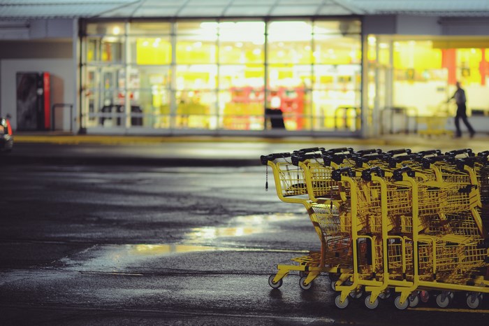 Yellow shopping trolleys in a wet parking lot at night