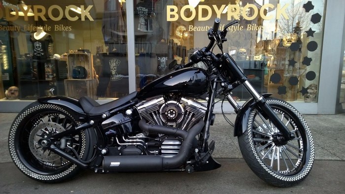 Black Harley Davidson motorcycle parked in front of Bodyrock store