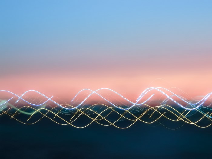 Abstract light trails over dark landscape at sunset