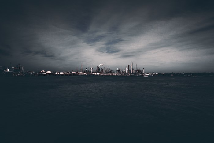 Oil refinery on the water under a cloudy sky