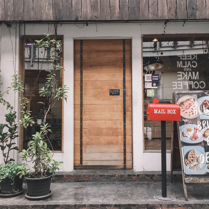 Coffee shop entrance with wooden door and mailbox