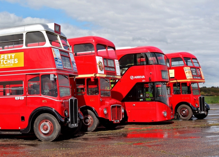 Four red double-decker buses lined up