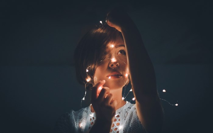Woman with fairy lights illuminating her face