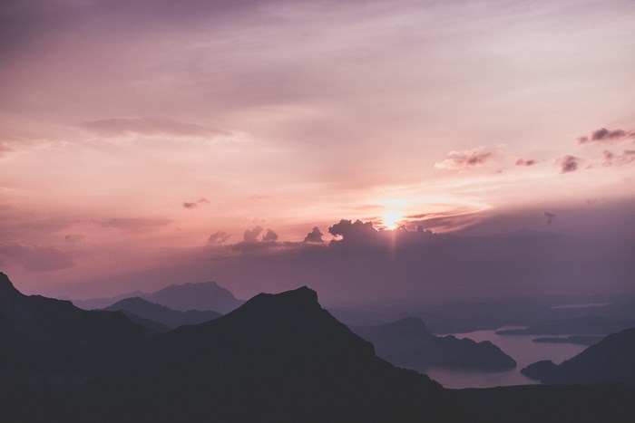 Silhouette of mountains and lake at sunset