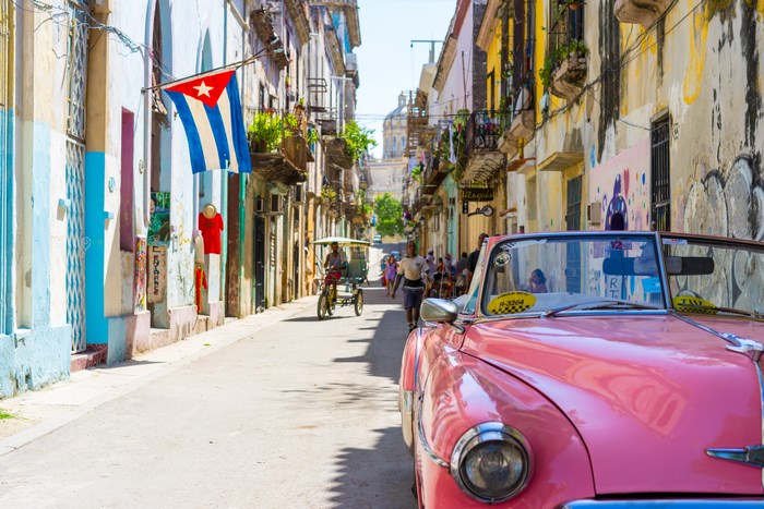 Classic pink convertible on a colorful street in Havana, Cuba