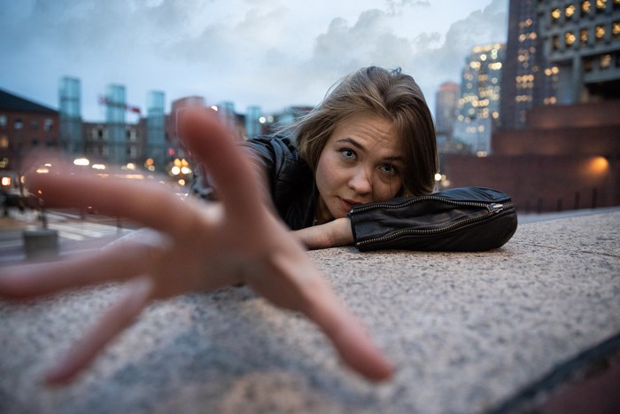 Woman in leather jacket reaching out