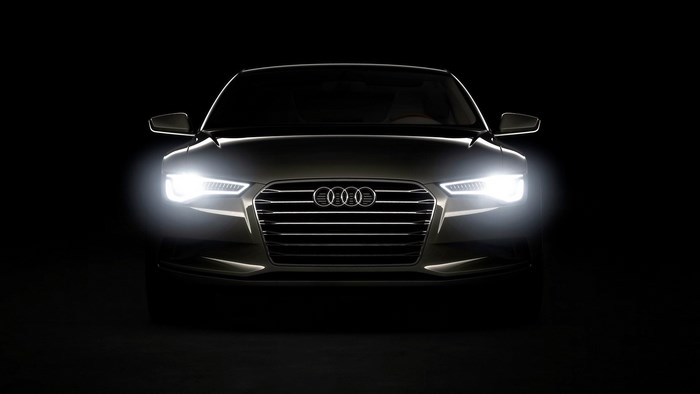 Audi car with headlights on black background