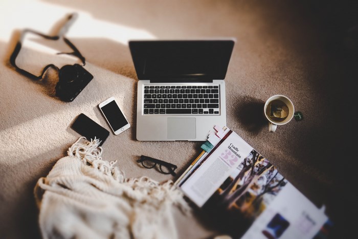 Laptop, camera, and phone on a carpeted floor