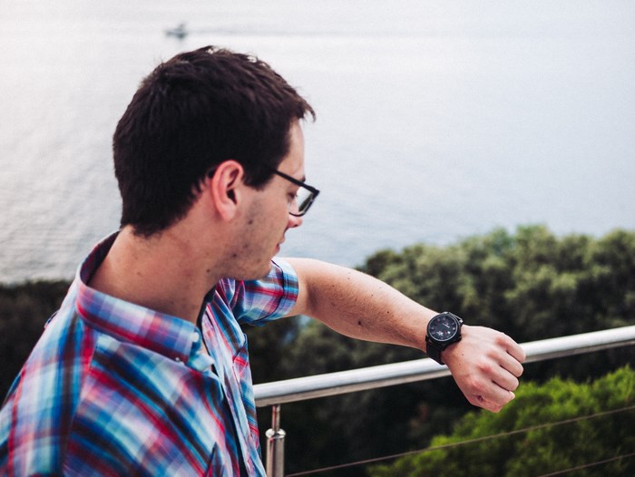 Man checking his watch by the sea