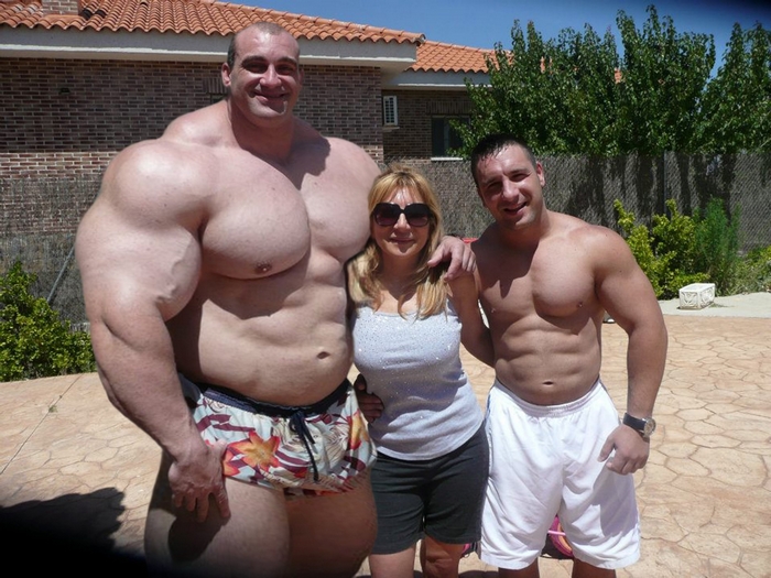 Bodybuilders posing with a woman outdoors