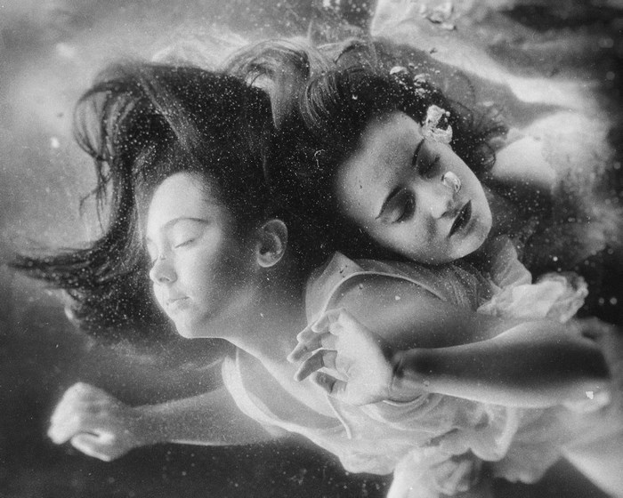 Two women underwater with hair flowing