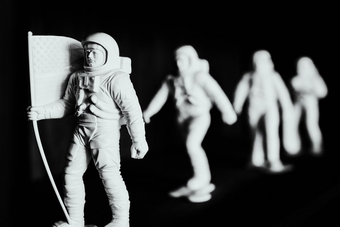 Astronaut figures holding an American flag