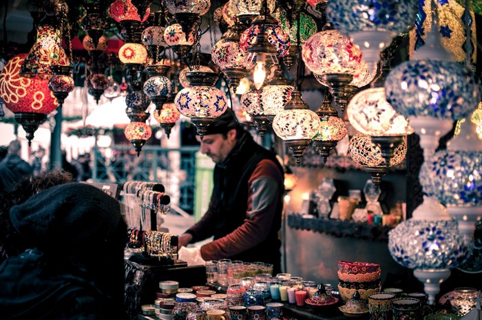 Man selling colorful lanterns at a market stall