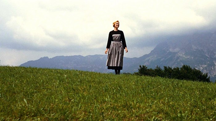 Maria from The Sound of Music on a grassy hill